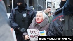 Российская полиция задерживает участницу антивоенного митинга в Петербурге, 24 февраля 2022 года