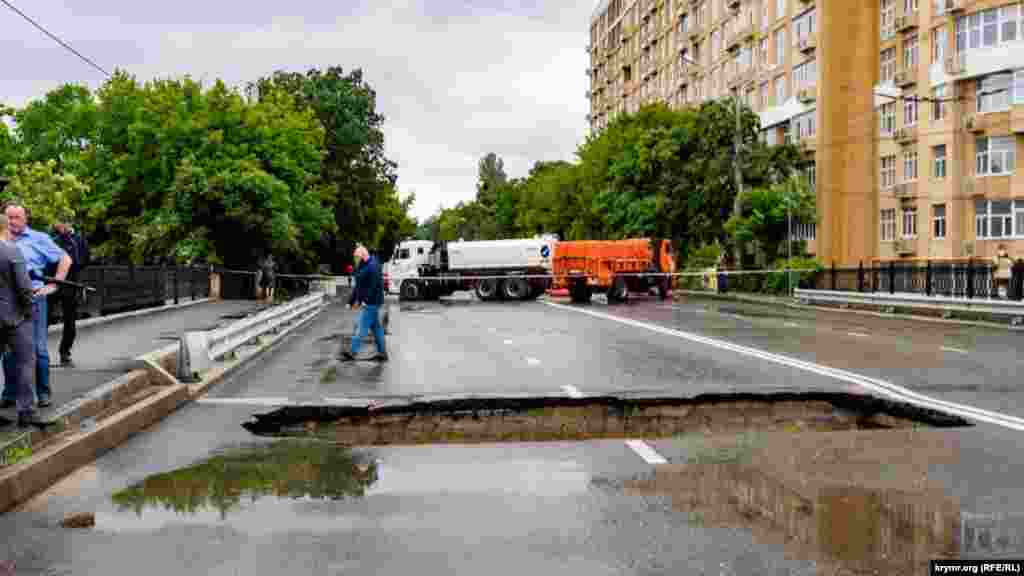 Большая вода вымыла проем в асфальтовом покрытии моста через Салгир на улице Толстого