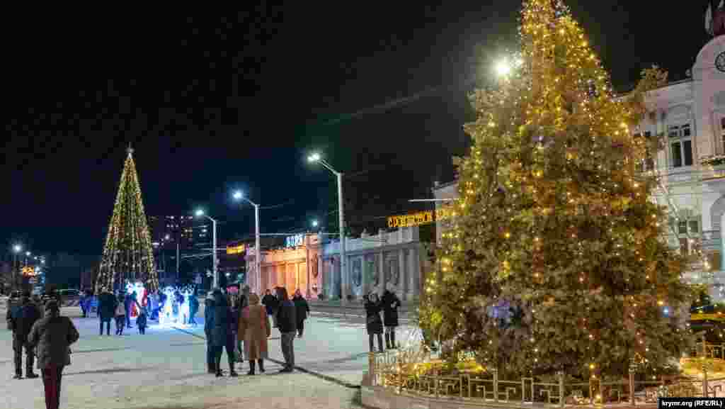 Впервые за 20 лет в этом году на Театральной площади установили искусственную главную городскую елку высотой 11 метров. Прежде такой роли удостаивалась живая, растущая, которую тоже украсили (справа)