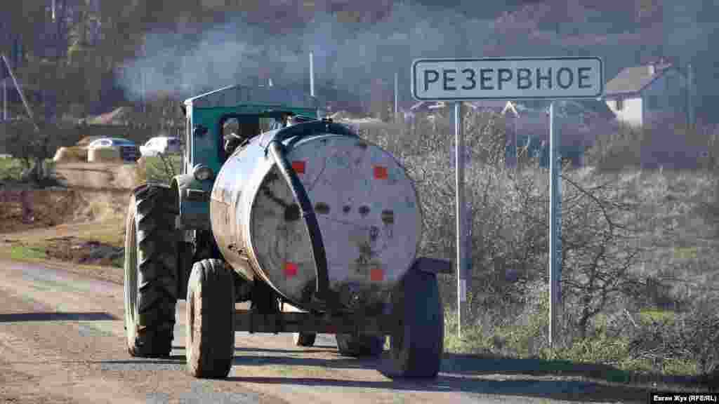 Тракторист везет техническую воду в Резервное