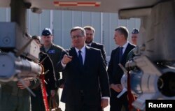 Президент Польши Бронислав Коморовский под крылом истребителя F-16 в ходе визита на базу ВВС